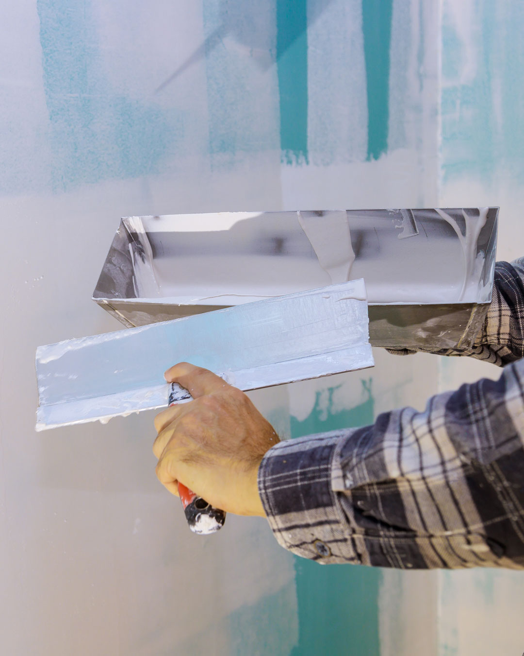 Joint compound being smoothed over a drywall seam with a taping knife